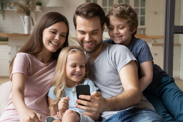 istock Family with kids using smartphone having fun at home 1198734146