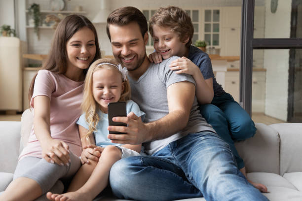 istock Married couple with kids play new game using smartphone 1198734154