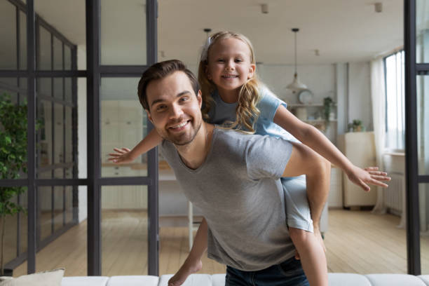 istock Happy young dad piggybacking playing with little daughter 1198734176
