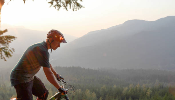 istock Mountain biker traverses path above mountains and valley 1198734393