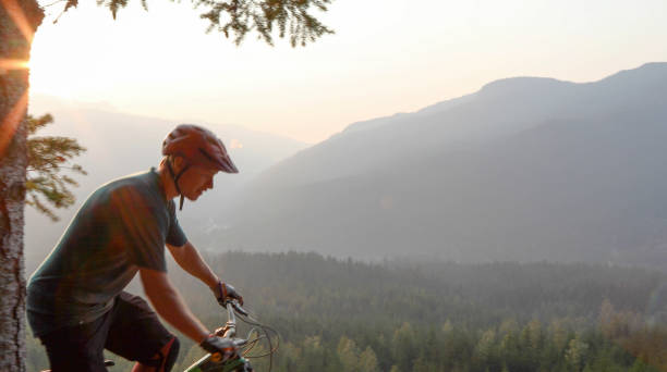 istock Mountain biker traverses path above mountains and valley 1198734394