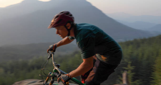 istock Mountain biker traverses path above mountains and valley 1198734445