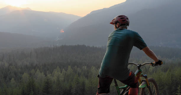 Mountain biker traverses path above mountains and valley