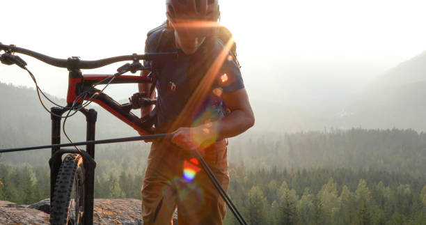 istock Mountain biker uses rope for ascent, above mountains and valley 1198734723