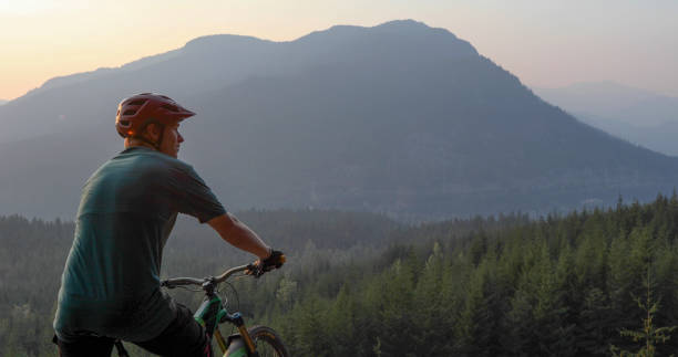 istock Mountain biker traverses path above mountains and valley 1198734727