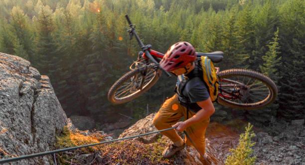 istock Mountain biker uses rope for ascent, above mountains and valley 1198734874