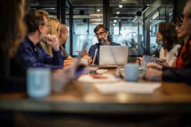 istock Smiling CEO talking to his employees during a meeting 1198734917