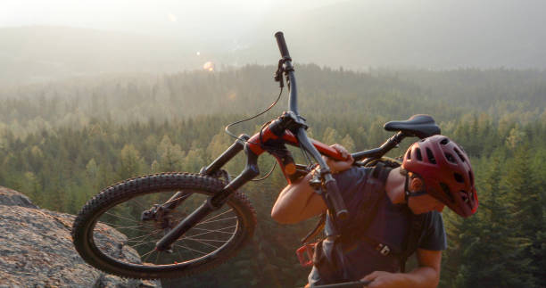 istock Mountain biker uses rope for ascent, above mountains and valley 1198735527