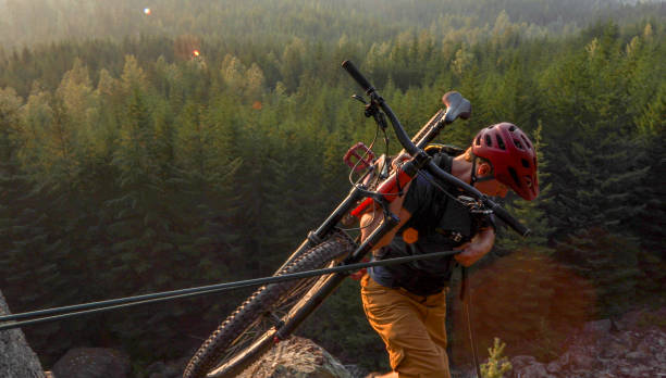 istock Mountain biker uses rope for ascent, above mountains and valley 1198735542