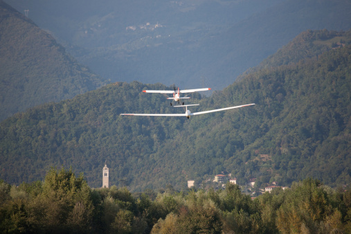 Glider towing over a country with a bell tower