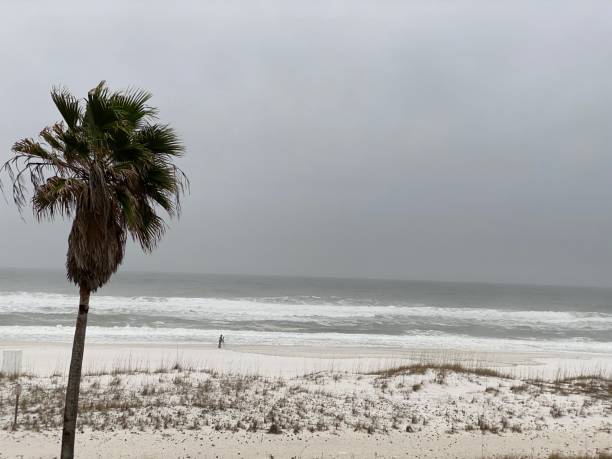 Pensacola Beach, FL, USA: Waves crashing on beach on overcast day in January stock photo
