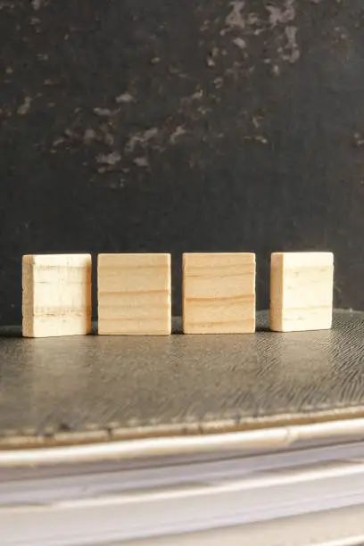 Photo of Blank wood scrabble pieces isolated on grunge black background.