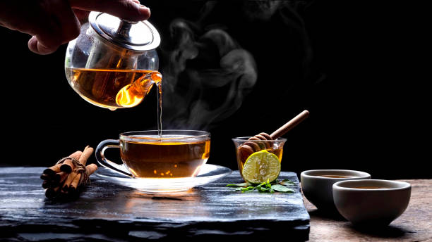 pouring hot aromatic herbal tea - tea cup cup china saucer fotografías e imágenes de stock