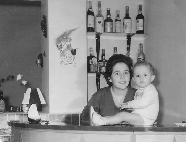 Vintage black and white image taken in 1960 of a Young woman posing with her one year old child boy Vintage black and white image taken in 1960 of a caucasian Young woman posing with her one year old child boy year 1960 stock pictures, royalty-free photos & images