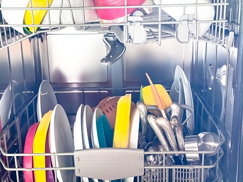 Interior del lavavajillas con platos limpios después del ciclo de lavado photo