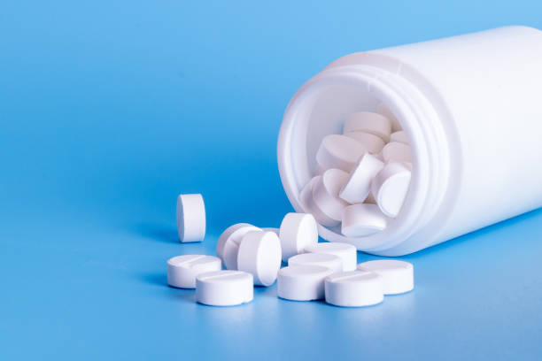 Oral medicine, paracetamol,white pills on blue background stock photo