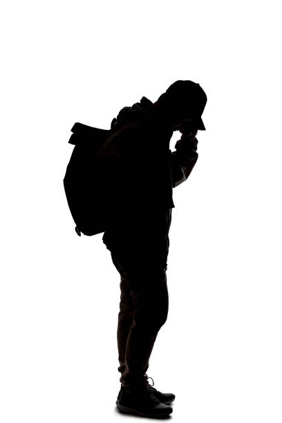 istock Silhouette of a Male Traveler or Backpacker Using a Cell Phone 1198760155
