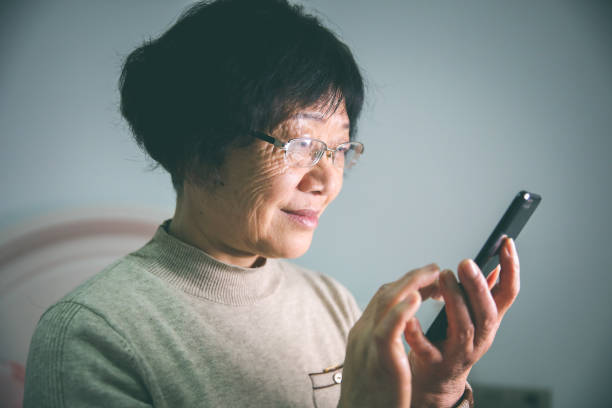 istock Senior asia women using mobile phone at home 1198762083