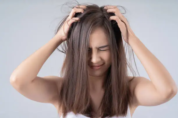 Asian woman. She is shocked at the damaged hair.