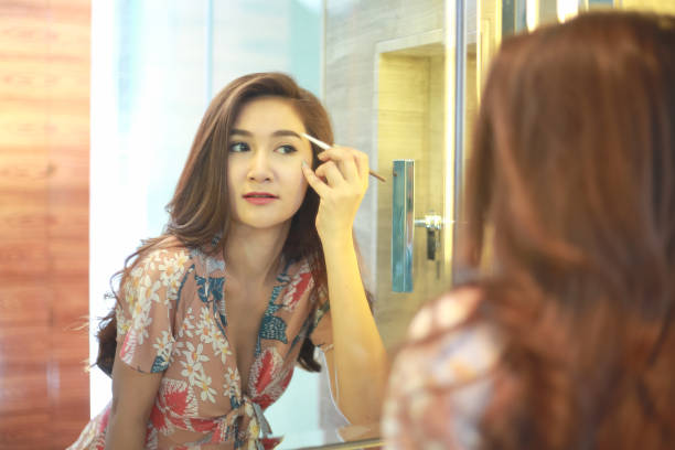 istock Beautiful Asian woman using eyebrow pencil make up in front mirror. 1198777397