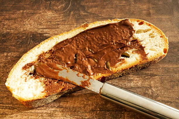 istock Bread with chocolate cream on wooden table 1198780343