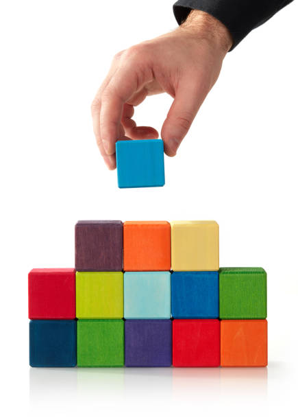 istock Hand putting wood cube block on top pyramid 1198780434