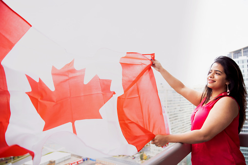 Indian, Girl, Patriotism, Canada Day - Indian girl holding Canadian flag while standing at her apartment balcony