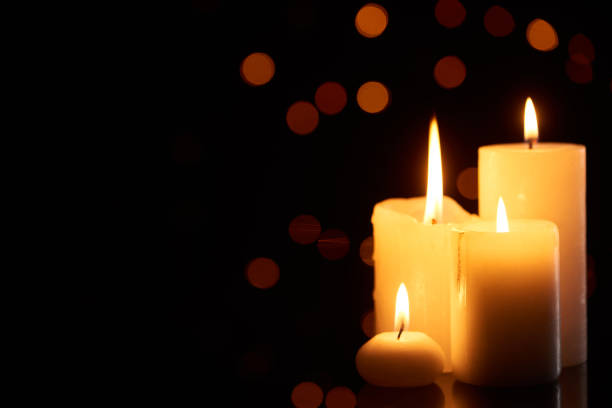 istock burning candles glowing in dark with bokeh lights on background 1198791099