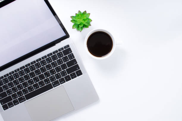 istock Top view of a laptop computer with a coffee cup on a modern style white desk. With copy space. 1198793720