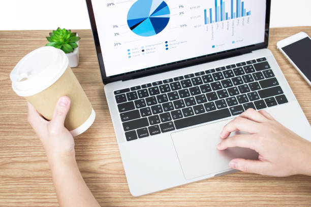 istock Side view picture of businessman analyzing financial graphs on the computer screen on a wooden table. Business concept. 1198793950