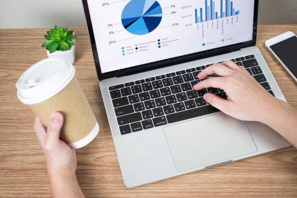 istock Close-up pictures of businessmen are analyzing financial graphs on the computer screen while drinking coffee at the same time. 1198794287
