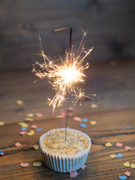 istock Cupcake with a lighted sparkler on a wooden background 1198795432