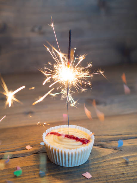 istock Cupcake with a lighted sparkler on a wooden background 1198795471