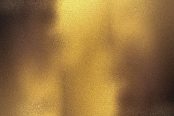 istock Brushed bronze foil metallic wall with glowing shiny light, abstract texture background 1198800945