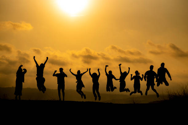istock Silhouette Friends Jumping Against Sky During Sunset 1198803664