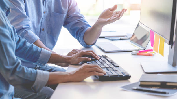 istock Midsection Of Business People Working On Table 1198811622