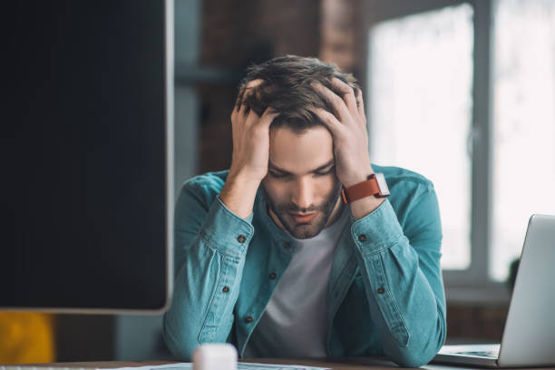 istock Good looking young man holding his head 1198814257