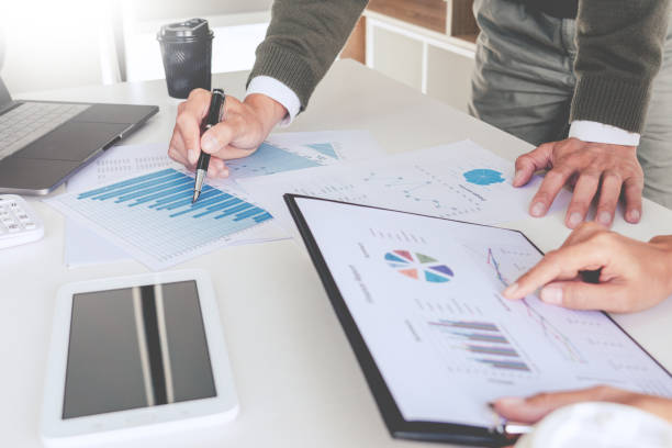 istock Midsection Of Business People Working Over Graphs On Table 1198816794