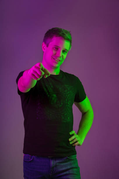 istock Caucasian man's portrait isolated on purple studio background in neon light 1198816914