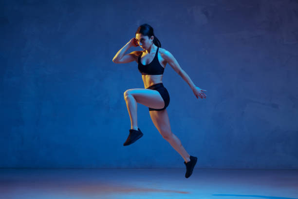 istock Caucasian young female athlete practicing on blue studio background in neon light 1198819887