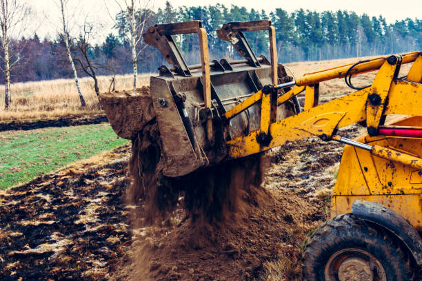 istock Excavator with a large iron bucket on a construction site during road works, Backhoe dig the ground for the foundation. 1198820154