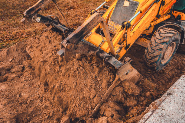 istock Excavator with a large iron bucket on a construction site during road works, Backhoe dig the ground for the foundation. 1198820695
