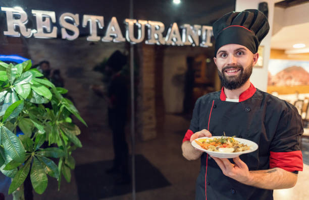 istock Young male chef presenting meals at the restaurant 1198823238