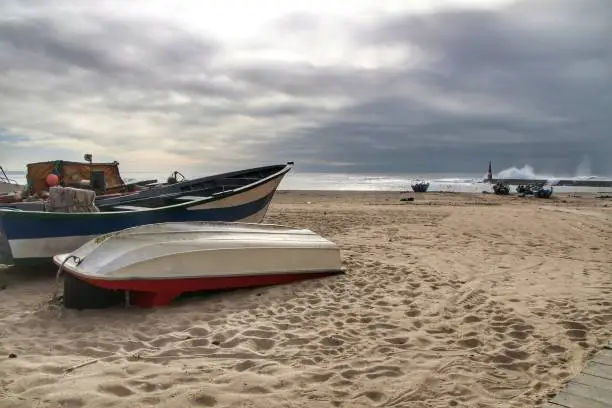 Photo of Fishing boats stranded on Aguda beach and Giant waves breaking on the breakwater