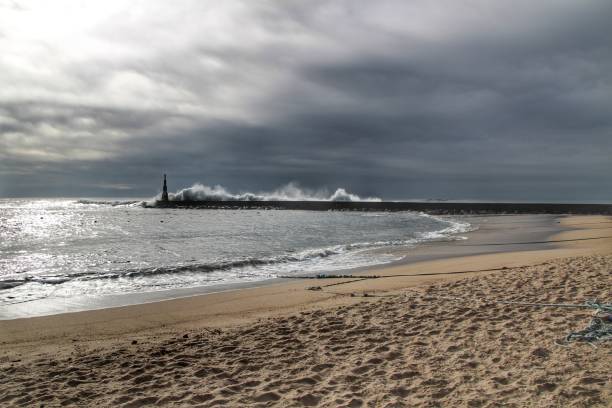 istock Giant waves breaking on the breakwater and the lighthouse 1198826927