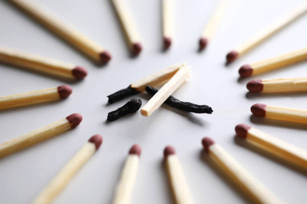 istock Broken burned out match in surrounded by evil intact fellows 1198827795