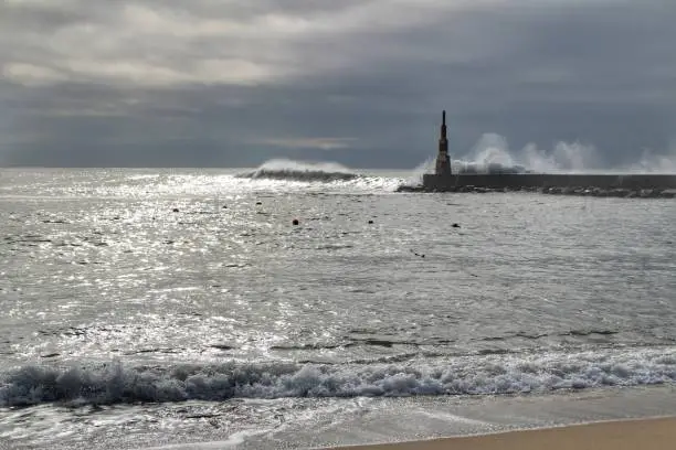 Photo of Giant waves breaking on the breakwater and the lighthouse