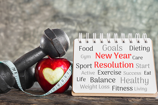 new year goals for sport concept with red apple,dumbbell and resolution list on paper