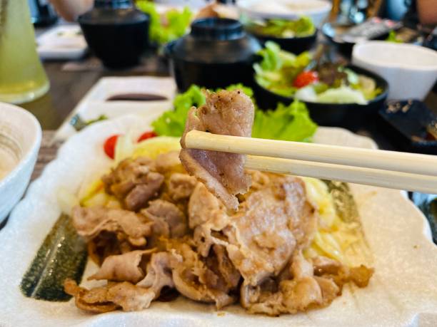 istock People using chopsticks with grilled pork slices. Korean cuisine BBQ at restaurant. Selective focus 1198832723