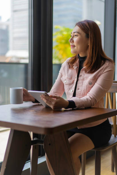 istock Asian business woman taking a coffee break from work. 1198837236